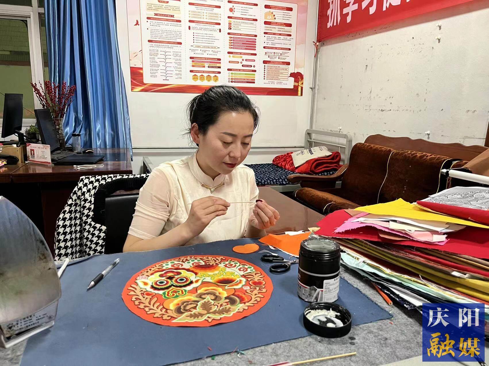 李慶英正在創(chuàng)作布貼畫作品。